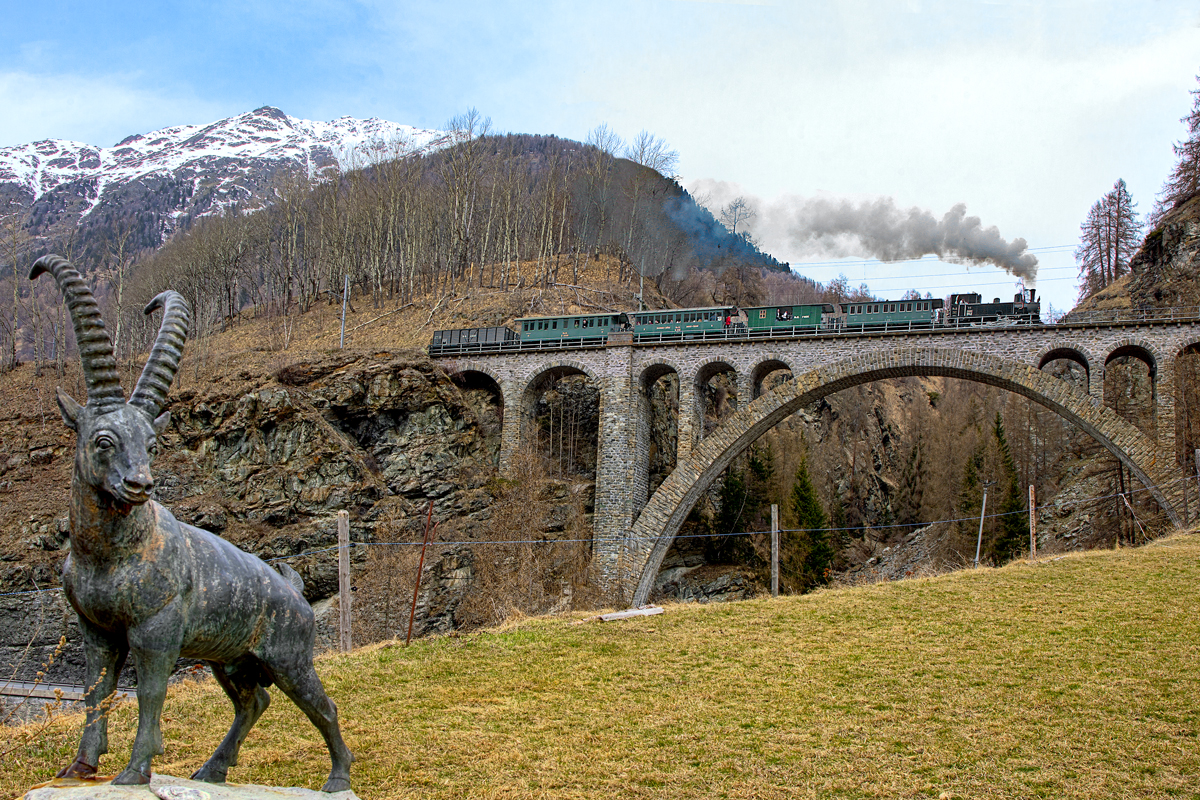 Die Jungfernfahrt mit den Helfern des Lok 11 Club 1889 führt die G 3/4 11 Heidi mit ihrem Sonderzug über das Val Tui Viadukt,dass den Bach Clozza überspannt,in Guarda vorüber.Bild vom 2.4.2016