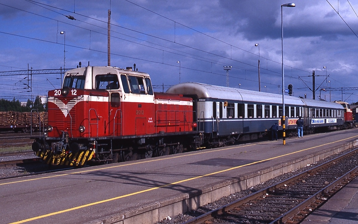 Die im Juni 1990 im Bahnhof Seinäjoki aufgenommene Dv15 2012 ist die letzte einer Serie von 57 Stangen-Diesellokomotiven, die die VR ab 1957 beschaffte und deren letzte Vertreterinnen bis 2004 im Einsatz standen