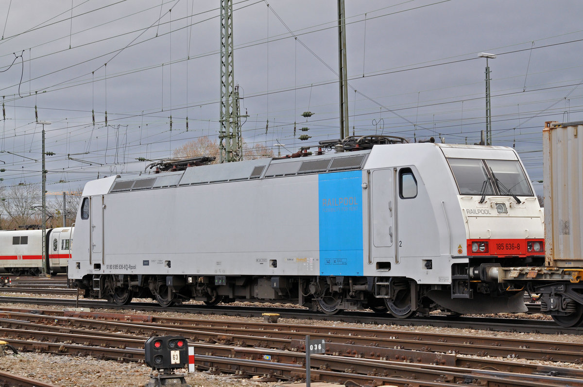 Die kalte Lok 185 636-8 durchfährt an einem Güterzug den Badischen Bahnhof. Die Aufnahme stammt vom 18.01.2018.