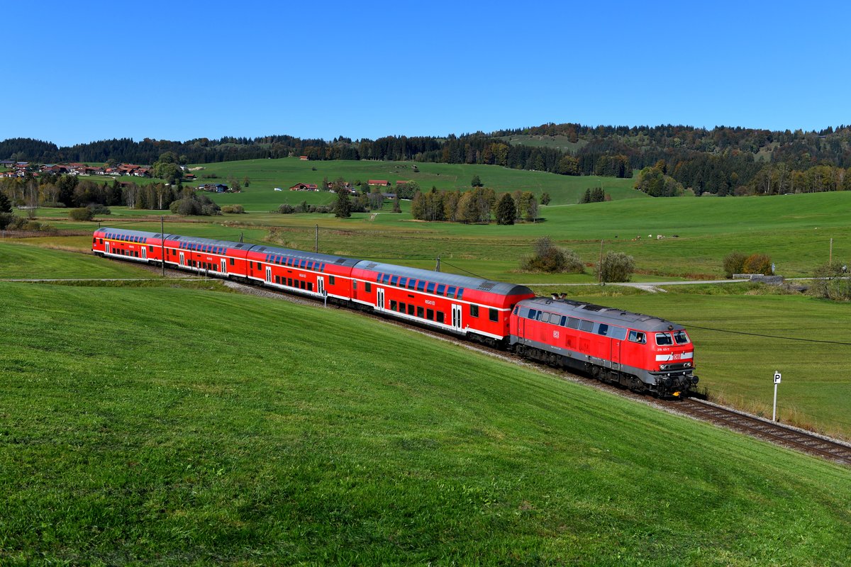 Die König-Ludwig-Bahn weist noch eine Telegraphen-Leitung und viele unbeschrankte Bahnübergänge auf und hat daher viel Nebenbahn-Charme. Am 14. Oktober 2018 konnte ich die bestens gepflegte 218 411 mit ihrem RE 57508 von München HBF und Füssen kurz hinter Hopferau fotografieren. Der Lokführer freute sich sichtlich, dass er an diesem Tage mehrfach aufgenommen wurde. Wunschgemäß hat er dieses Bild auch im Nachgang als Erinnerung an die Dienste von DB Regio auf dieser Strecke erhalten.