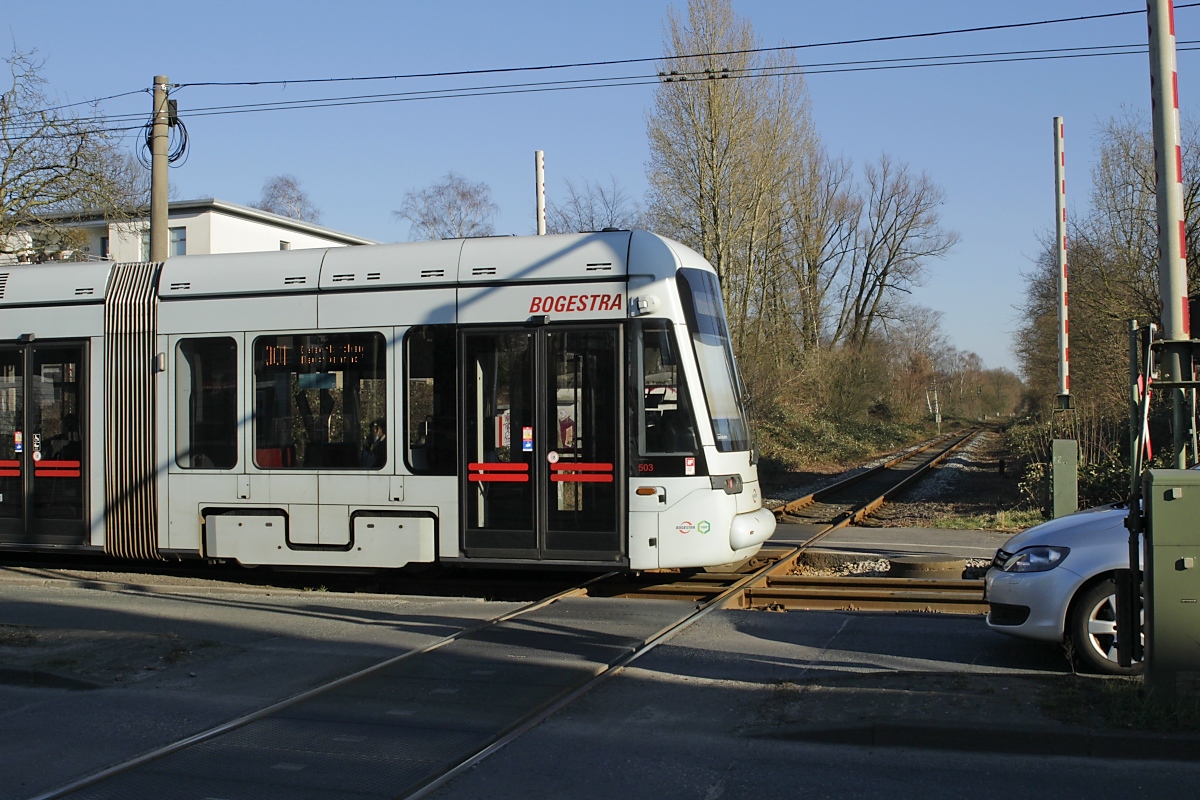 Die Kreuzung der Emschertalbahn mit der Bogestra-Straßenbahnlinie 301 in Gelsenkirchen-Beckhausen am 08.03.2022, im Vordergrund Tw 503