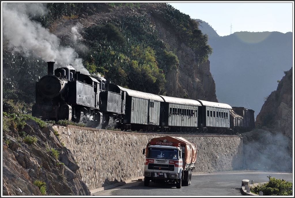 Die Lastwagenkonkurrenz hat der Bahn zwischen Massawa und Asmara längst die Transporte abgenommen. Während beim GmP wieder mal eine Lok den Geist aufgegeben hat, kriecht ein IVECO Truck dan Berg hoch Richtung Hauptstadt. (10.12.2014)
