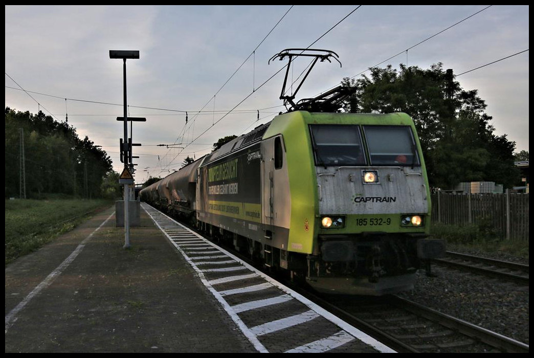 Die letzte Abendsonne spiegelt sich hier am 14.06.2021 um 20.46 Uhr in der Captrain Werbelok 185532-9, als diese mit einem Containerzug in Richtung Münster durch den Bahnhof Kattenvenne fährt.