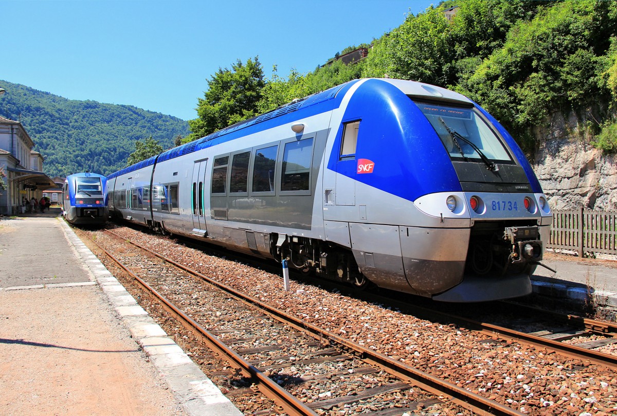 Die Ligne des Hirondelles: Der Dreiwagenzug 81733/34 ist ein elektro-diesel Zug (bimode). Von St.Claude aus fährt er das Tal hinab als Dieselzug, unter dem Fahrdraht Gleichstrom 1500 V hebt er den Pantographen und fährt elektrisch. St.Claude, 30.Juni 2015. 