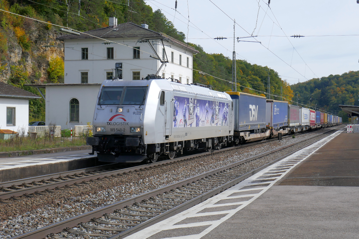 Die Lokomotive 185 540 (A-TXLA) mit dem schönen Namen  Oma Liesel  und Werbung für die  Kassel Huskies  durchfährt Eichstätt Bahnhof in Richtung Treuchtlingen und weiter nach Norden. Am Haken hat sie einen Zug des kombinierten Ladungsverkehrs. 
Eichstätt Bahnhof, 5. Oktober 2022