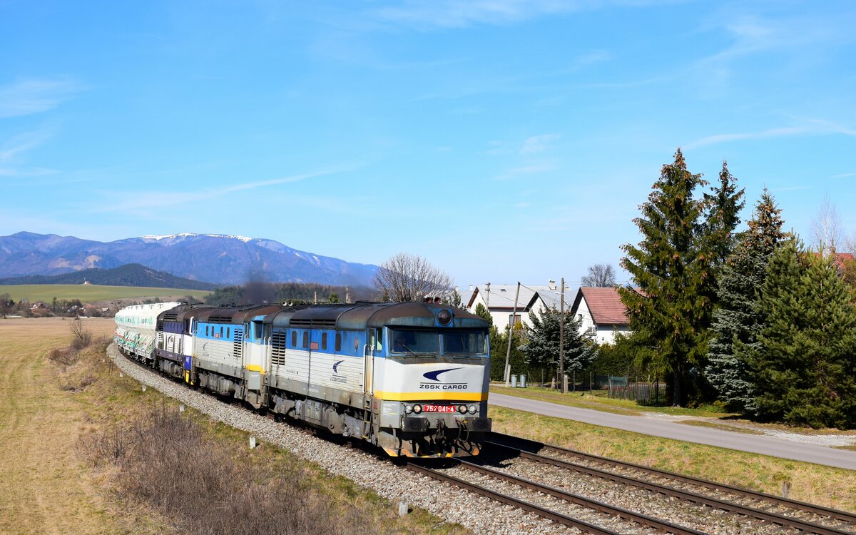 Die Loks 752 041 + 752 018 + 756 010 sind unterwegs von Lietavská Lúčka nach Zemianske Kostoľany mit dem Pn 55721  Ekocell-Express  bei Jazernica. 18.03.2023.