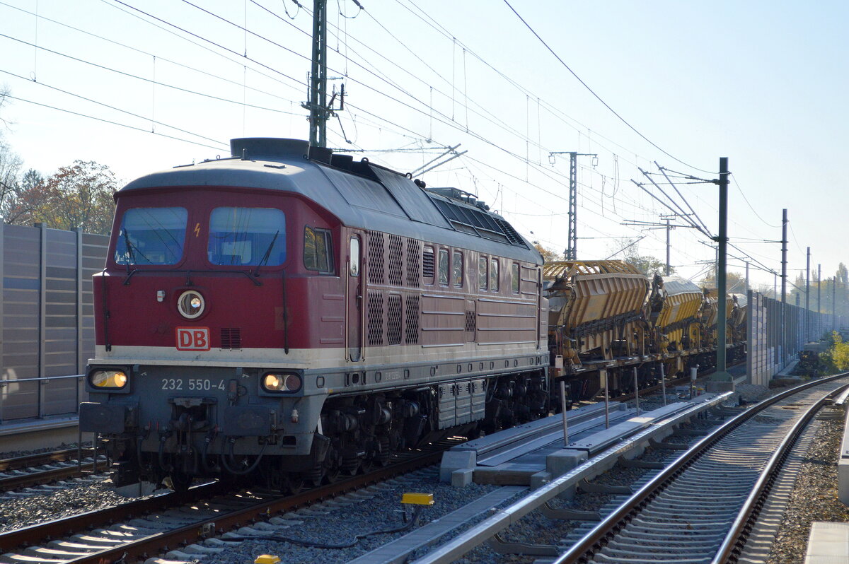 Die Ludmilla  232 550-4  (NVR:  92 80 1232 550-4 D-DB ) der DB Bahnbau Gruppe mit einigen Materialförder- und Silowagen am 29.10.21 Berlin Karow.