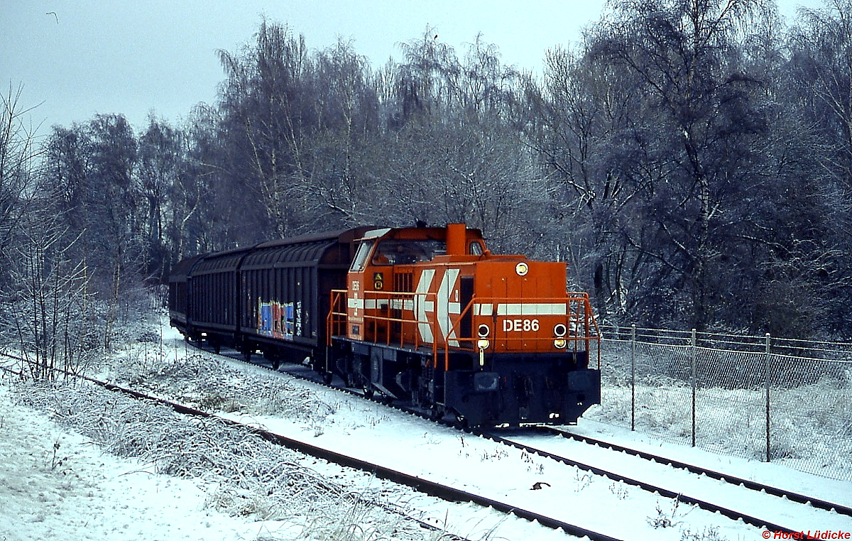 Die MaK DE 86 der HGK hat sich am 17.12.2010 mit einigen Güterwagen im Rheinhafen Stürzelberg auf den Weg nach Nievenheim gemacht, hier in St. Peter. 
