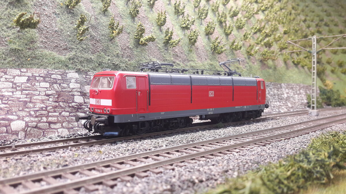 Die Mehrsystemlokomotive 181.2 wurde ab 1974 in einer Stückzahl von 25 Stück gebaut, als Nachfolgerin der Vorserie E320 ( Baureihe 181.0 u 181.1) und E410 ( BR 184) weiterentwickelt. Vorrangig für den Verkehr Deutschland - Frankreich u Luxemburg. Hier ein Modell in der letzten Lackierung ( Verkehrsrot ) in den Weinbergen von Harrstadt. Modell Roco 181 216-3 , 63719 DC digital