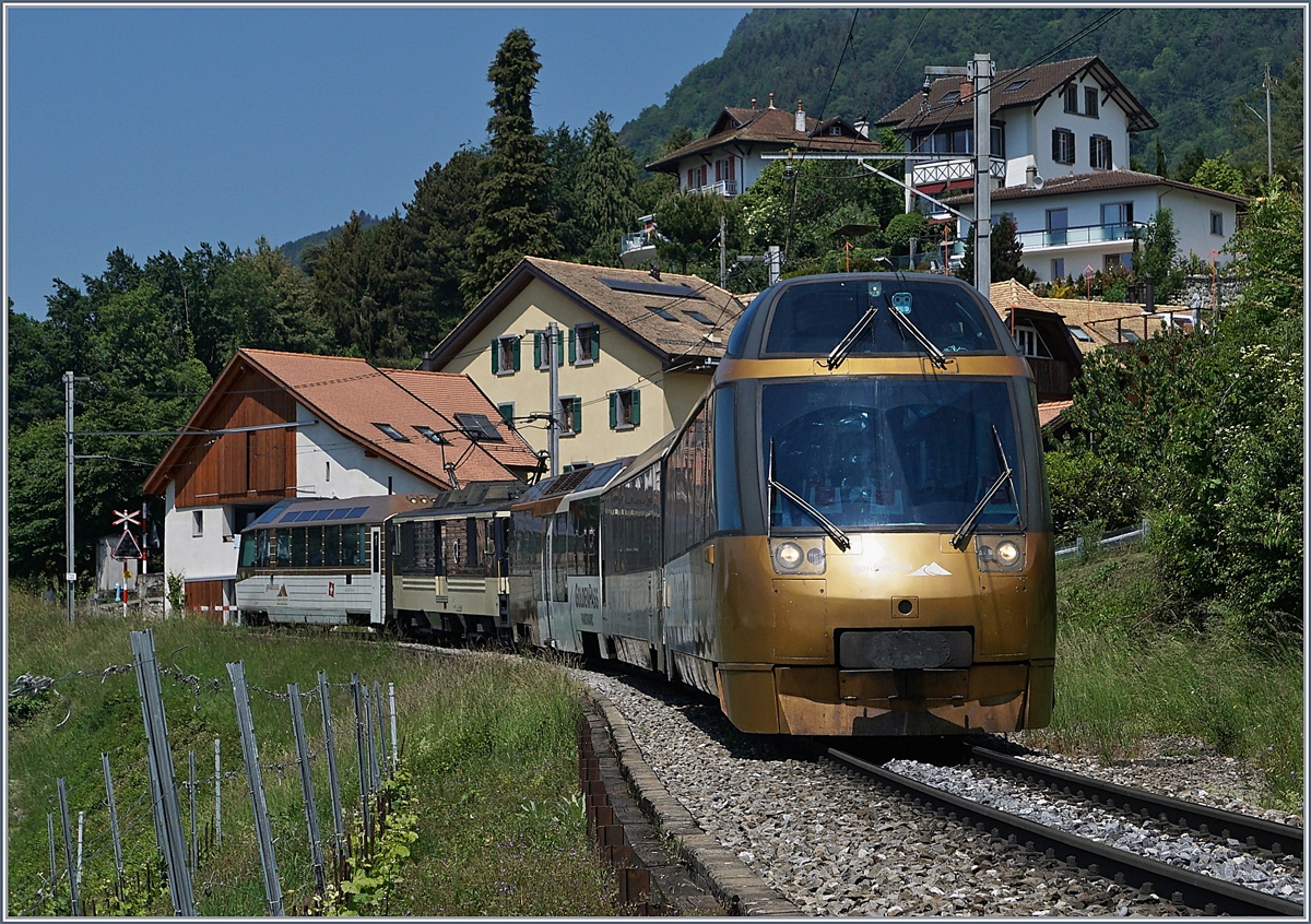 Die MOB GDe 4/4 6004  Interlaken  im hinteren Zugsteil eingereiht, ist mit ihrem Panoramic Express von Zweisimmen nach Montreux bei Planchamp unterwegs. 
An der Zugsspitze zeigt sich der markante GoldenPass Pannoramic Steuerwagen Ast 152 und am  Zugschluss läuft der Ast 117. 

18. Mai 2020