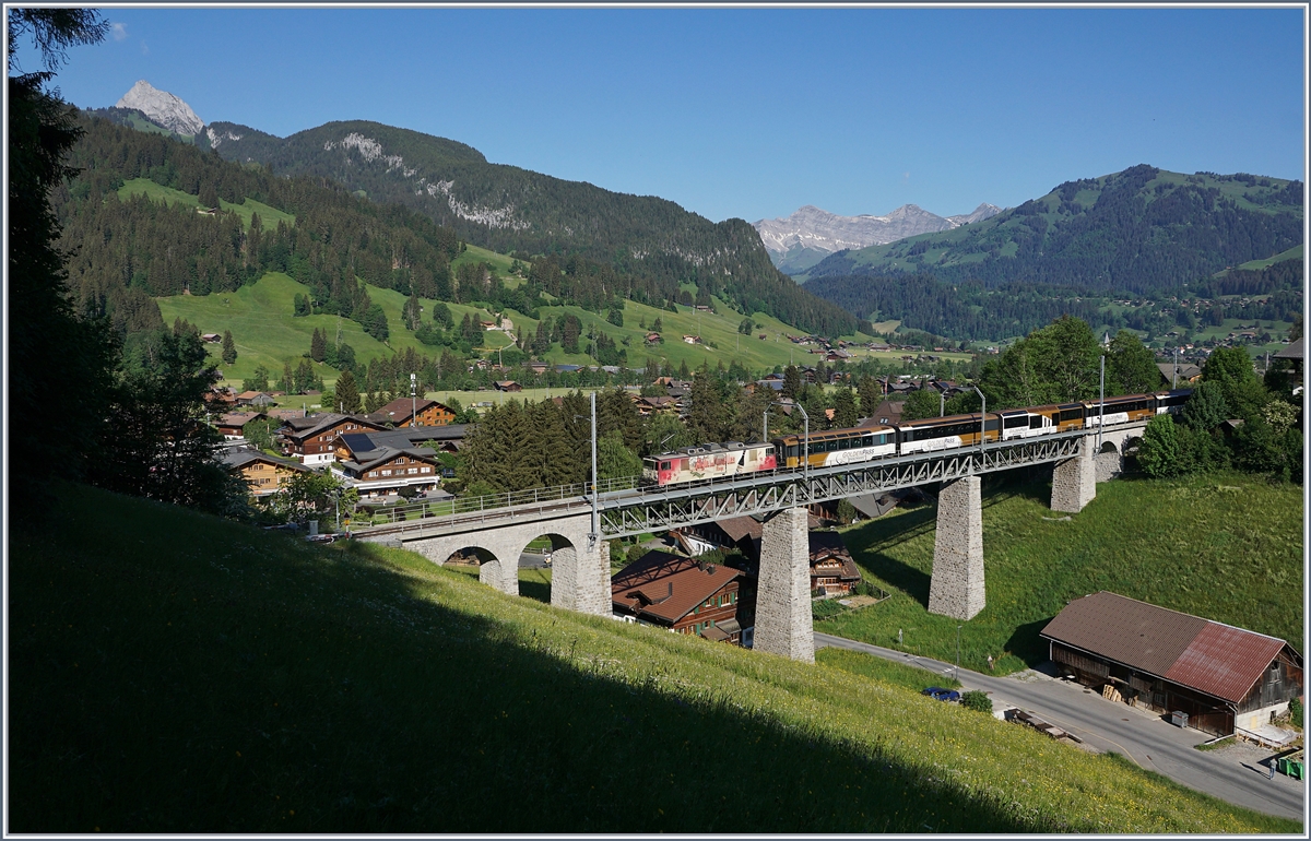 Die MOB GDe 4/4 6006 (ex GFM/TPF) überquert mit ihrem PE 2111 von Zweisimmen nach Montreux die Grubenbach Brücke bei Gstaad.

2. Juni 2020