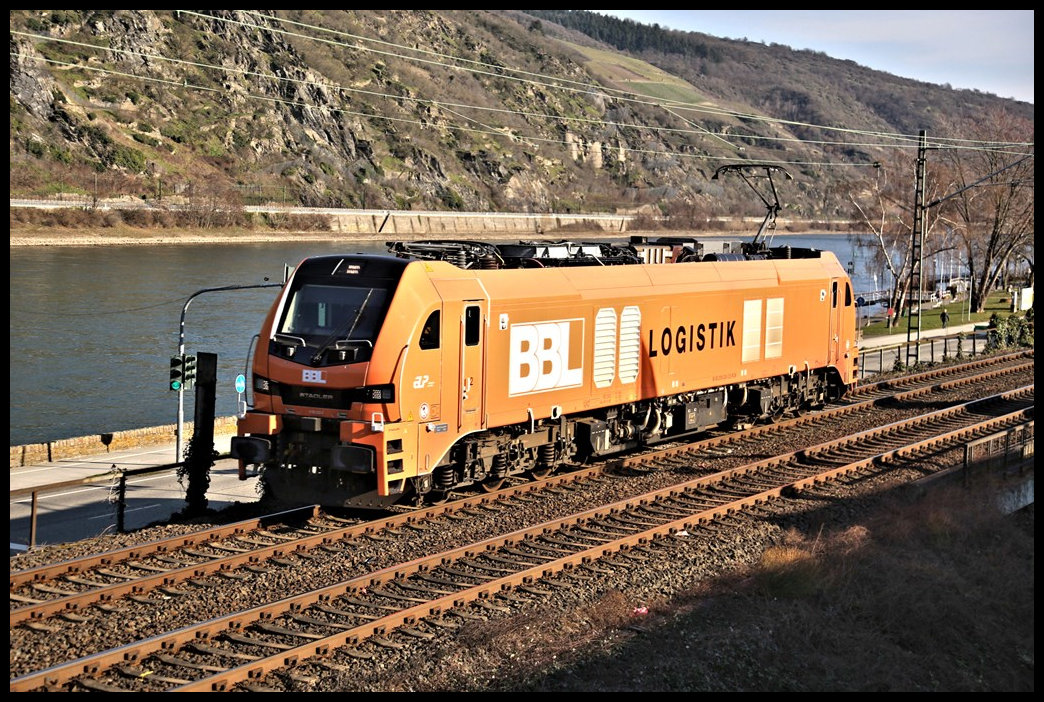 Die nagelneue BBL 159230-2 Eurodual Lokomotive von Stadler ist hier linksrheinisch Richtung Koblenz unterwegs. am 28.2.2023 um 15.17 Uhr passiert sie die alte Stadtmauer von Oberwesel, welche um diese Uhrzeit bereits lange Schatten wirft.