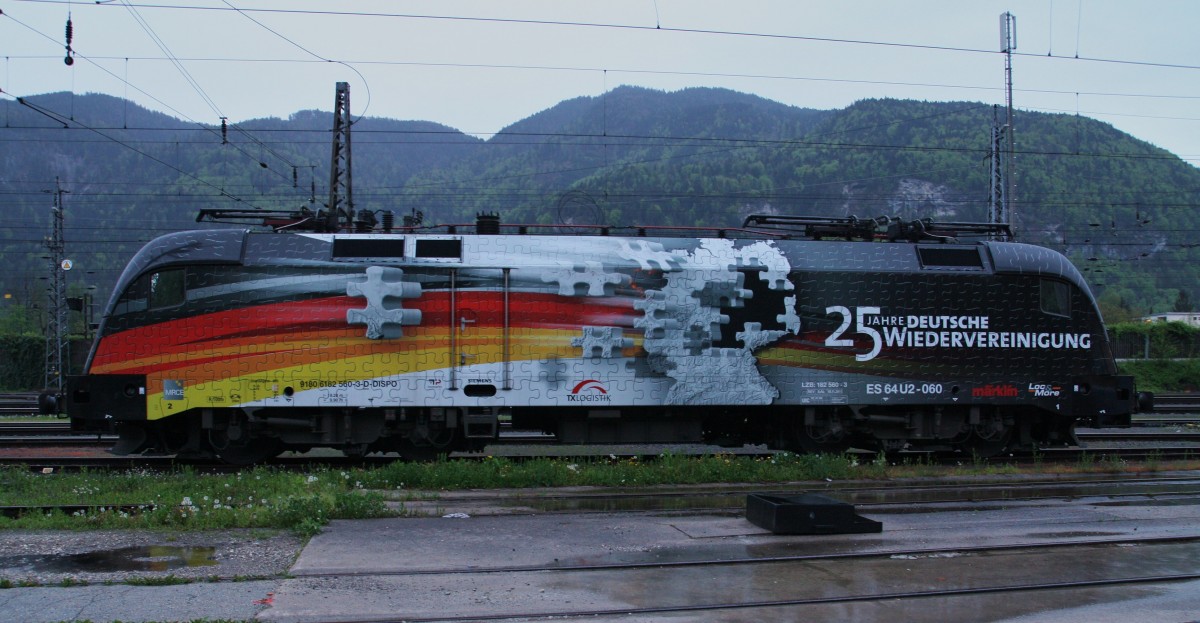 Die ``neu`` beklebte 182 560-3 von TXL steht am 3.5.2015 in Kufstein. Sie macht Werbung für  25 Jahre Deutsche Wiedervereinigung  zwischen Ost- und Westdeutschland. 