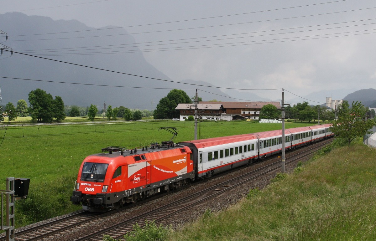 Die neu getaufte 1116 072-0 ``Bodensee`` der ÖBB Rail Cargo Group in Zusammenarbeit mit der Firma Gebrüder Weiss (Gemeinsam Erfolge Transportieren)ist am 3.6.2014 mit dem IC 860 ``St. Anton am Arlberg`` von Wien West nach Bregens unterwegs. Hier bei Kirchbichl im Tiroler Unterland mit Blick auf den Berg  Pendling, der im Regen verschwindet.