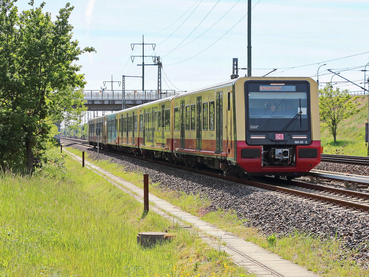 Die Neue DB S-Bahn Berlin (BR 484) in Richtung Bahnhof Berlin Flughafen Schönefeld am 21. Mai 2020. Fotostandort an der Waßmannsdorfer Chaussee (B 96) in einer Grünanlage.