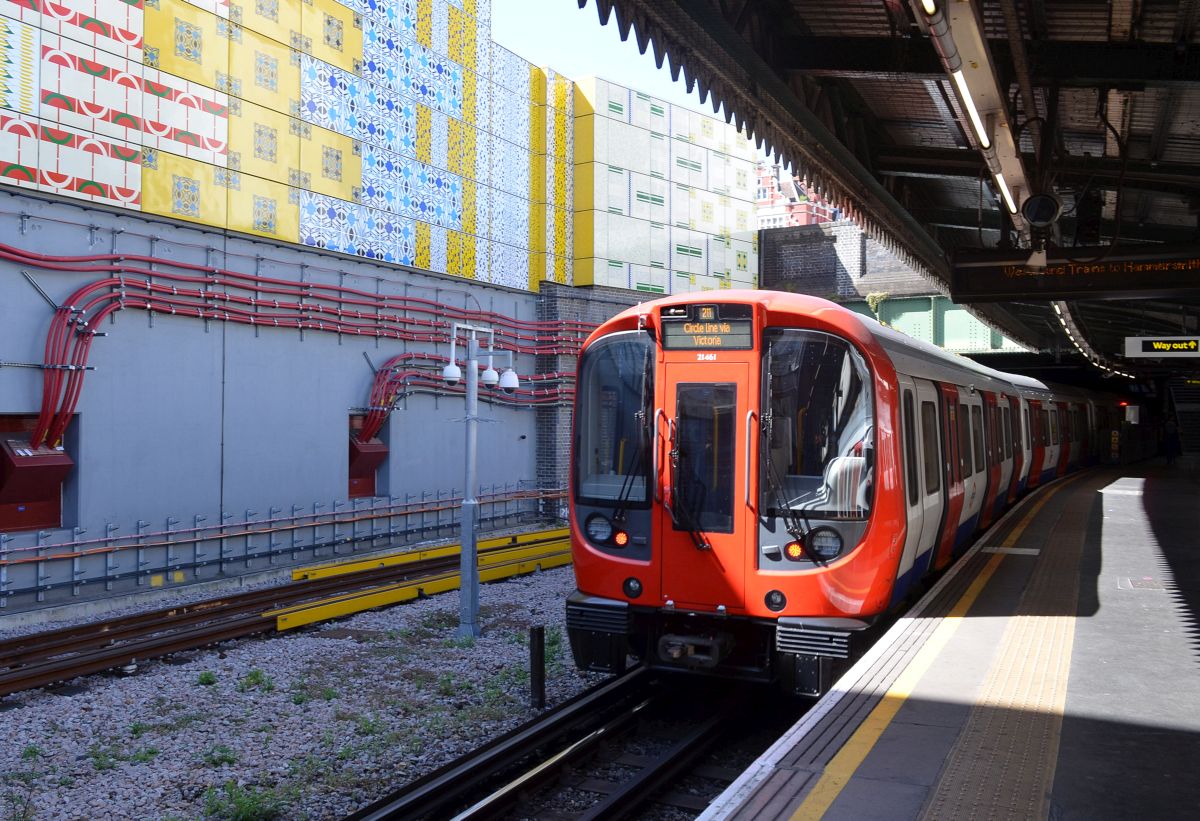 Die neue  S-Klasse  der London Underground in der Station  Edgeware Road  - vor der Kulisse des  Wrapper , dem angeblich größten Emaille-Kunstwerk der Welt. 10.7.2015