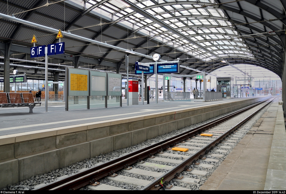 Die neue Westseite in Halle(Saale)Hbf: ein Rundgang (Bild 3)
***
Am ersten Adventssonntag wurden im Knoten Halle (Saale) die Bahnsteige 4/5 und 6/7 samt neuem Sanitärbereich und denkmalgerecht rekonstruierten Arkaden feierlich wiedereröffnet. In einer kleinen virtuellen Führung möchte ich Euch die modernisierten Anlagen vorstellen.

Nach der Besichtigung der Arkaden auf dem Hans-Dietrich-Genscher-Platz (Bahnhofsvorplatz) gehen wir zum Empfangsgebäude und nehmen die Treppe hoch zur Bahnhofslounge, in dessen Nähe sich auch der DB-Infopunkt Bau befindet, der interessante Einblicke in das hiesige Baugeschehen gibt. Von dort ausgehend gelangt man hinaus auf einen kleinen Weg zwischen Gebäude und Gleisanlagen (hier nicht ersichtlich), der sonst nur für Bahnmitarbeiter zugänglich ist.
Wir können hier schon einen Blick auf den Bahnsteig 6/7 erhaschen, an dem sich die beiden Gleise der Bahnstrecke Berlin–Halle (KBS 250) befinden, weshalb dort hauptsächlich der Fernverkehr halten soll. Im Vordergrund sind sehr gut die ETCS2-Balisen erkennbar, welche auf dem Großteil der Neu- und Ausbaustrecke München–Berlin (VDE 8) verbaut worden sind. Ebenso sind hier aber nach wie vor noch (Ks-)Signale und PZB-Gleismagneten vorhanden.
Noch fahren zum Aufnahmezeitpunkt im gesamten Bahnhof aber noch keine Züge. Erst am morgigen 2.12. um 4:00 Uhr wird die Westseite für den regulären Verkehr in Betrieb genommen. Seit dem 28.11. ist der Knoten voll gesperrt, um die neuen Gleisanlagen in die elektronische Stellwerkstechnik einzubinden.

[1.12.2019 | 15:49 Uhr]