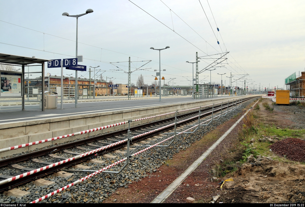 Die neue Westseite in Halle(Saale)Hbf: ein Rundgang (Bild 7)
***
Am ersten Adventssonntag wurden im Knoten Halle (Saale) die Bahnsteige 4/5 und 6/7 samt neuem Sanitärbereich und denkmalgerecht rekonstruierten Arkaden feierlich wiedereröffnet. In einer kleinen virtuellen Führung möchte ich Euch die modernisierten Anlagen vorstellen.

Seitenwechsel:
Nachdem wir uns die südliche Ausfahrt der Westseite angeschaut haben, lege ich hier ein Vergleichsbild mit der im November 2017 eröffneten Ostseite (Gleise 8–13) dazwischen.
Im Vordergrund ist der Bahnsteig 8/9 erkennbar, der wie Bahnsteig 6/7 überwiegend dem Fernverkehr dient. Gleis 8 wird in der Regel von ICE genutzt, während die IC-Züge Gleis 9 ansteuern.
Betrieb herrscht dort aber ebenfalls keiner, denn seit dem 28.11. ist der Knoten voll gesperrt, um die neuen Gleisanlagen der Westseite in die elektronische Stellwerkstechnik einzubinden. Erst am morgigen 2.12. um 4:00 Uhr rollt der Zugverkehr wieder, dann auf beiden Seiten.

[1.12.2019 | 15:25 Uhr]