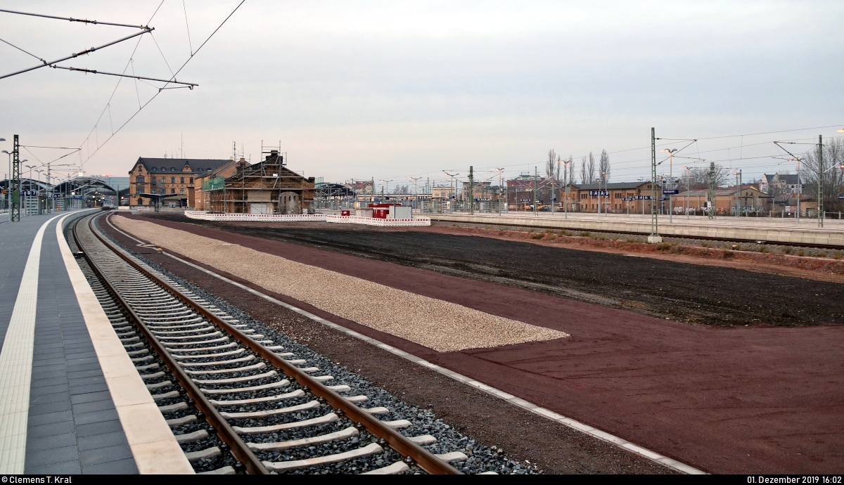 Die neue Westseite in Halle(Saale)Hbf: ein Rundgang (Bild 29)
***
Am ersten Adventssonntag wurden im Knoten Halle (Saale) die Bahnsteige 4/5 und 6/7 samt neuem Sanitärbereich und denkmalgerecht rekonstruierten Arkaden feierlich wiedereröffnet. In einer kleinen virtuellen Führung möchte ich Euch die modernisierten Anlagen vorstellen.

Am südlichen Ende des Bahnsteig 6/7 kann man noch einmal den Blick Richtung Ostseite (Gleise 8–13) schweifen lassen.
Zwischen Gleis 7 und 8 sind das Empfangsgebäude, die Dienststelle der Bundespolizei sowie ein alter Wagenschuppen angesiedelt. Bei der Sanierung des ebenfalls dort anzutreffenden Postbahnsteigs wurden die Gleise ersatzlos abgetragen. Die nun freigewordene Fläche wird für Rettungsfahrzeuge freigehalten.

[1.12.2019 | 16:02 Uhr]