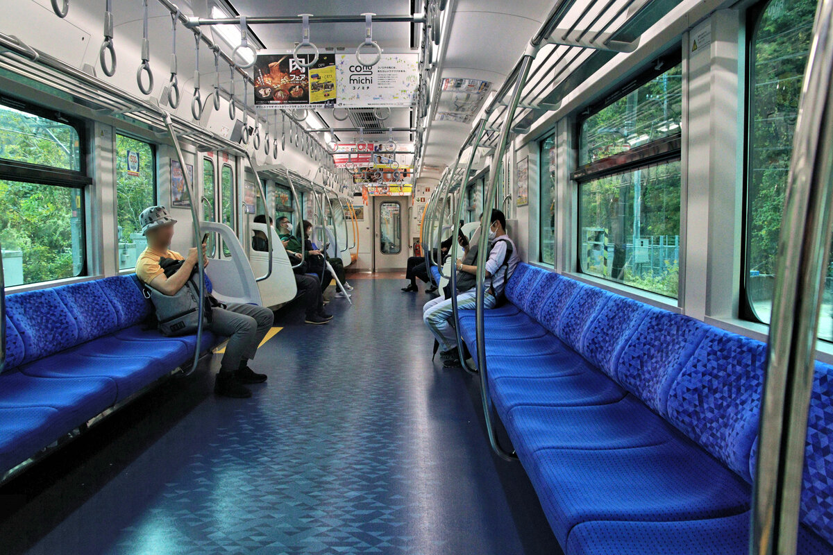 Die neuen Vororts- und Regionalzüge Serie 315 von JR Tôkai (JR Central): Die Züge haben Längssitze und sind damit auf eine sehr dichte Belegung ausgerichtet. Wie in neuster Zeit üblich hat der Innenraum kräftige, warme Farben. Blick in den Steuerwagen KUHA クハ315-1. 6.November 2023 