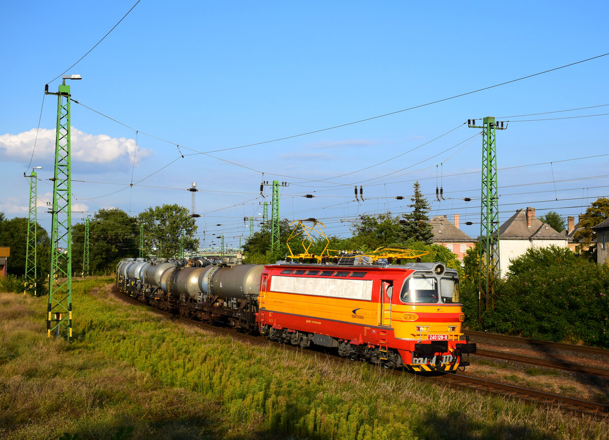 Die neulackierte 240 128-er Laminátka mit einem Duslo Kesselwagenzug bei der Abfahrt von Komárom Richtung nach der Slowakei. Die Lok früher war bei der EVU PSŽ a.s.
Komárom, 20.08.2021.