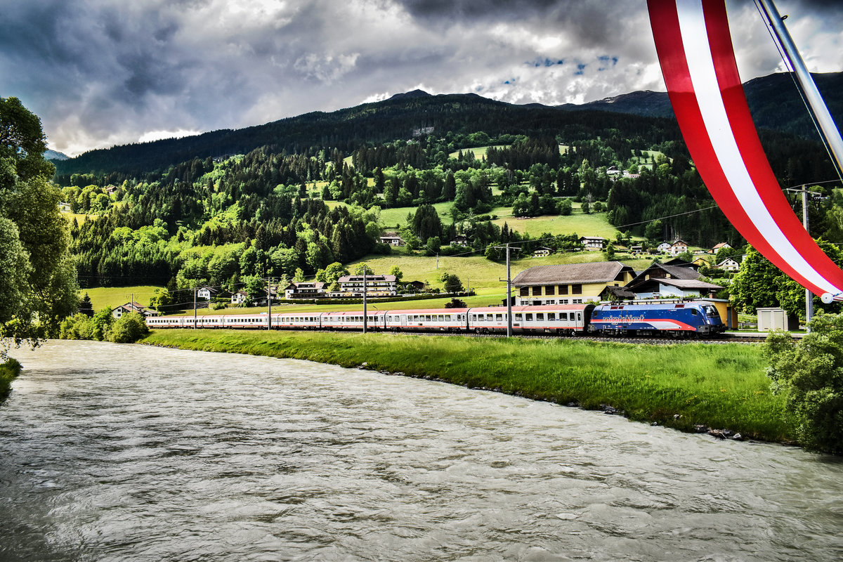 Die  Nightjet-Lok  1116 195-9, durchfährt mit dem IC 632  Lienzer Dolomiten , die Haltestelle Berg im Drautal.
Aufgenommen am 25.5.2018.