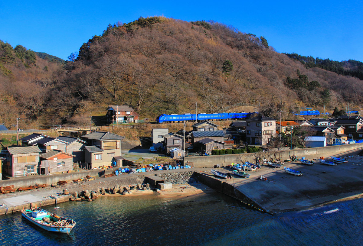 Die Nordwestküste Japans, Hauptlinie Niigata - Akita am Japanischen Meer: Ein Expresszug Serie 653 von Niigata nach Akita im Fischerdörfchen Wakigawa. 18.März 2019 