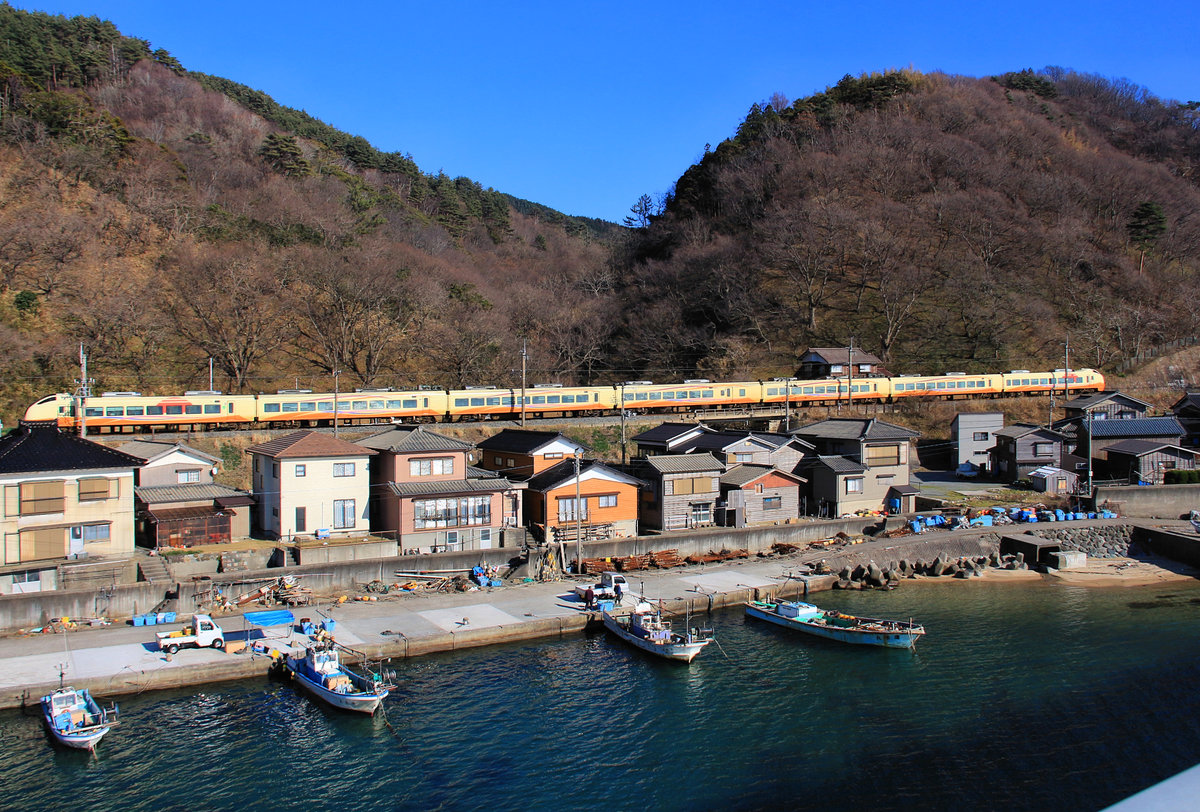 Die Nordwestküste Japans, Hauptlinie Niigata - Akita am Japanischen Meer: Ein Expresszug Serie 653 von Akita nach Niigata im Fischerdörfchen Wakigawa. 18.März 2019  
