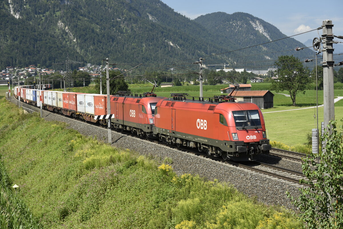 Die ÖBB 1116 032 und ein weiterer Taurus, auf der Inntalstrecke kurz nach Kufstein, nahe der Ortschaft Langkampfen in Richtung Brenner. Aufgenommen am 28.07.22