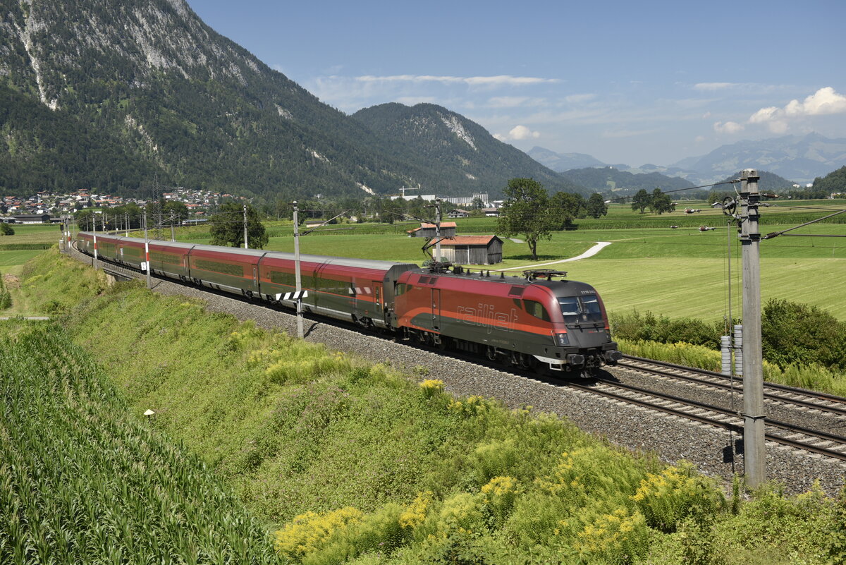 Die ÖBB 1116 243 mit einem Railjet auf der Inntalstrecke kurz nach Kufstein, nahe der Ortschaft Langkampfen. Aufgenommen am 28.07.22
