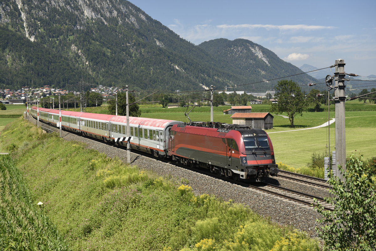 Die ÖBB 1216 019 mit dem DB-ÖBB EuroCity EC 83 München - Verona  auf der Inntalstrecke kurz nach Kufstein, nahe der Ortschaft Langkampfen. Aufgenommen am 28.07.22