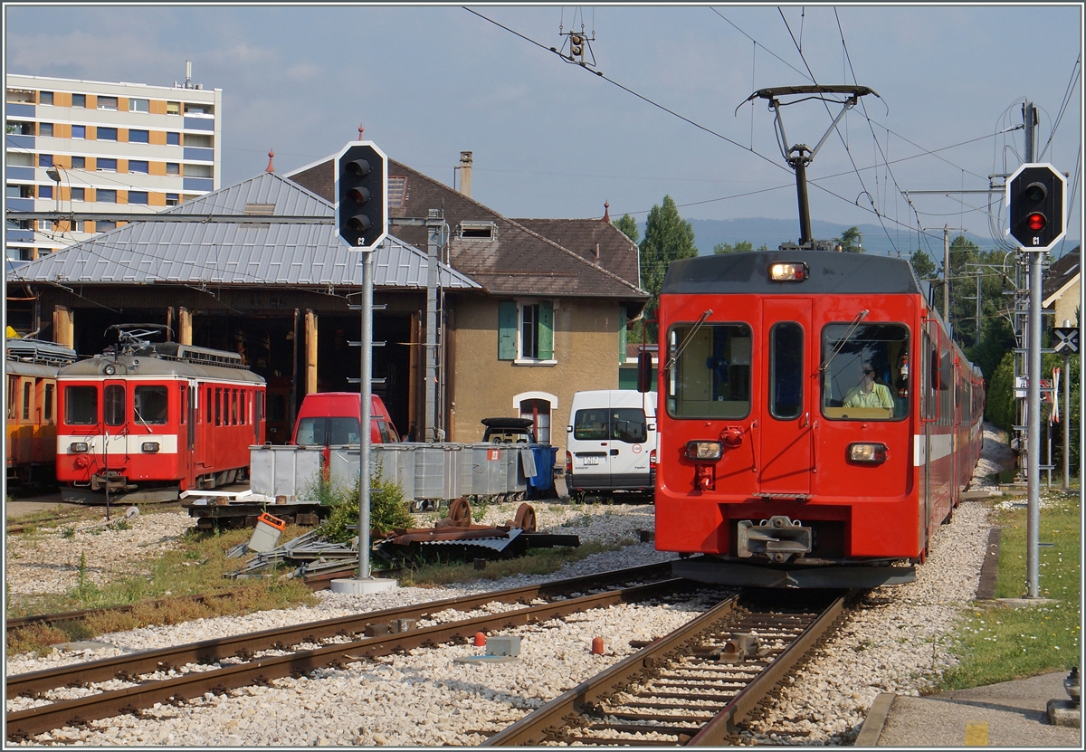 Die von Oranges befreit Stirnfront der NStCM BDe 4/4 Triebwagen wirkt noch etwas ungewohnt im Gegensatz zur CJ Lackierung des Triebwagens ganz links im Bild.
Der NStCM Regionalzug 119 von La Cure nach Nyon erreicht Les Plantaz, die  Dépôt -Station der NStCM.
6. Juli 2015