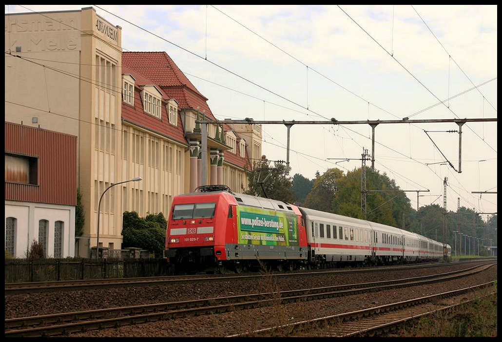 Die Polizei Werbelok 101029-7 kommt hier am 25.9.2005 mit dem Intercity aus Berlin durch den Bahnhof Melle und passiert das links sichtbare dortige Automuseum.