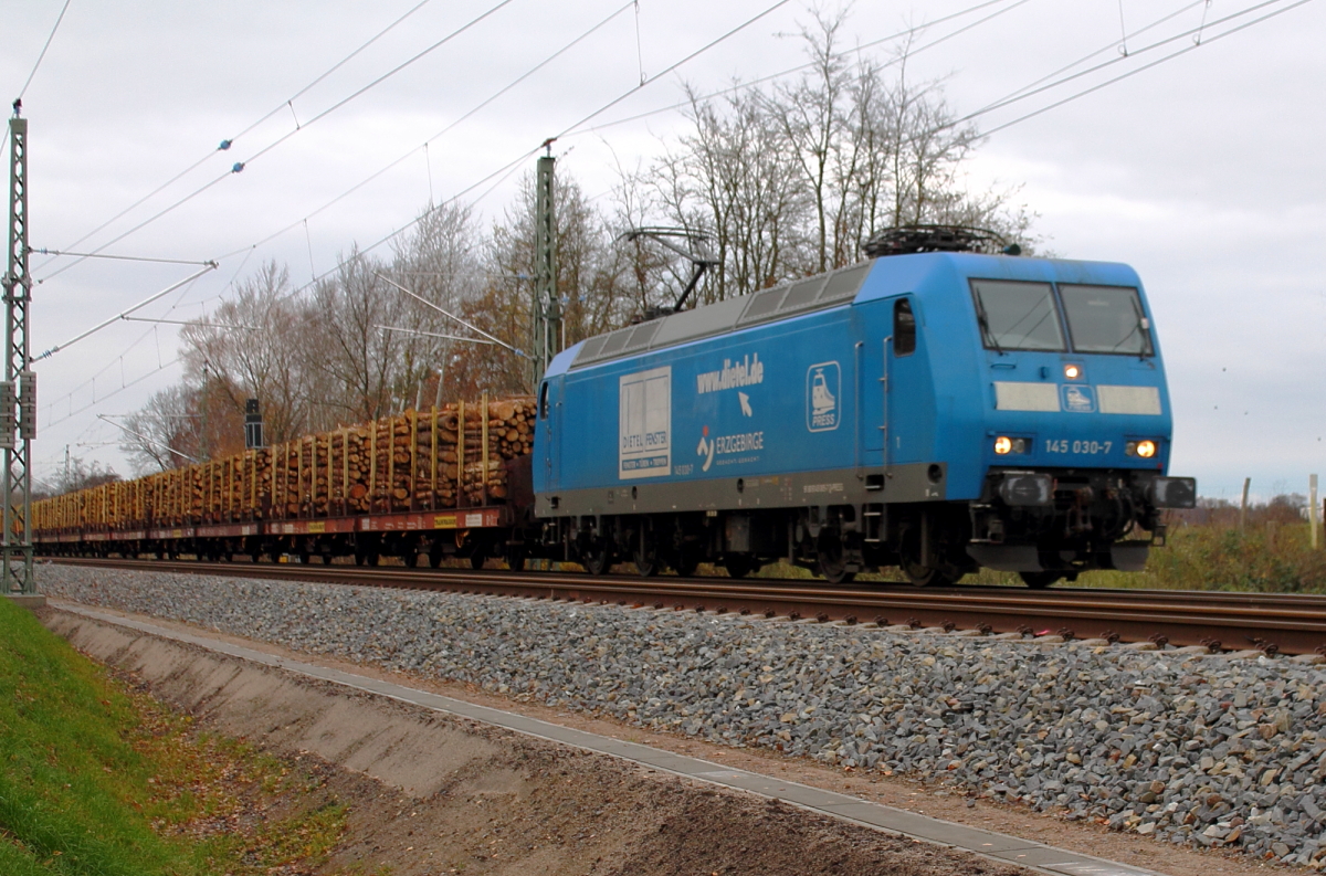 Die PRESS 145 030-7 mit einem Holzzug bei der Durchfahrt in Nassenheide am 23.11.2013.

NVR-Nr.: 91 80 6145 085-7 D-PRESS
Hersteller: ADtranz 
Baujahr: 2000
Fabriknummer: 33380