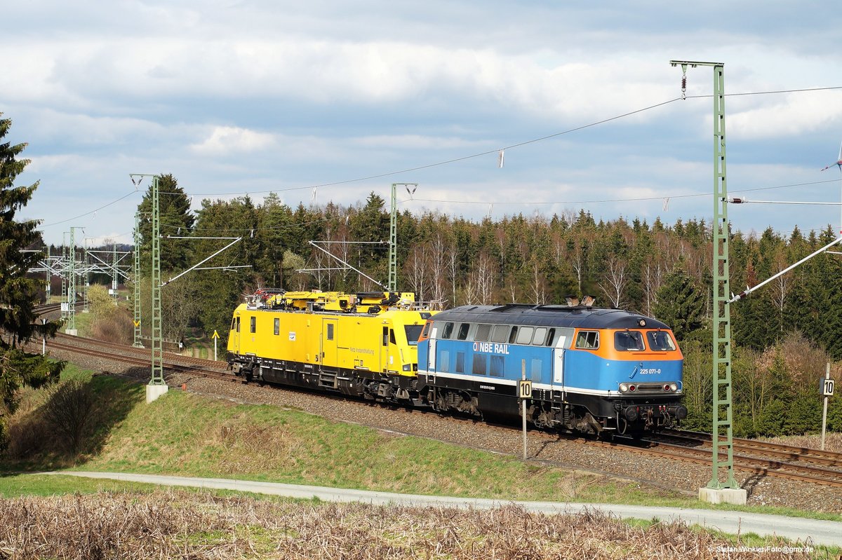 Die private bunte 225071 kommt hier mit gelbem Revisionstriebwagen im Schlepp auf der Hauptbahn von Plauen entgegen. Aufnahme am 08.04.2016 hinter Feilitzsch.
