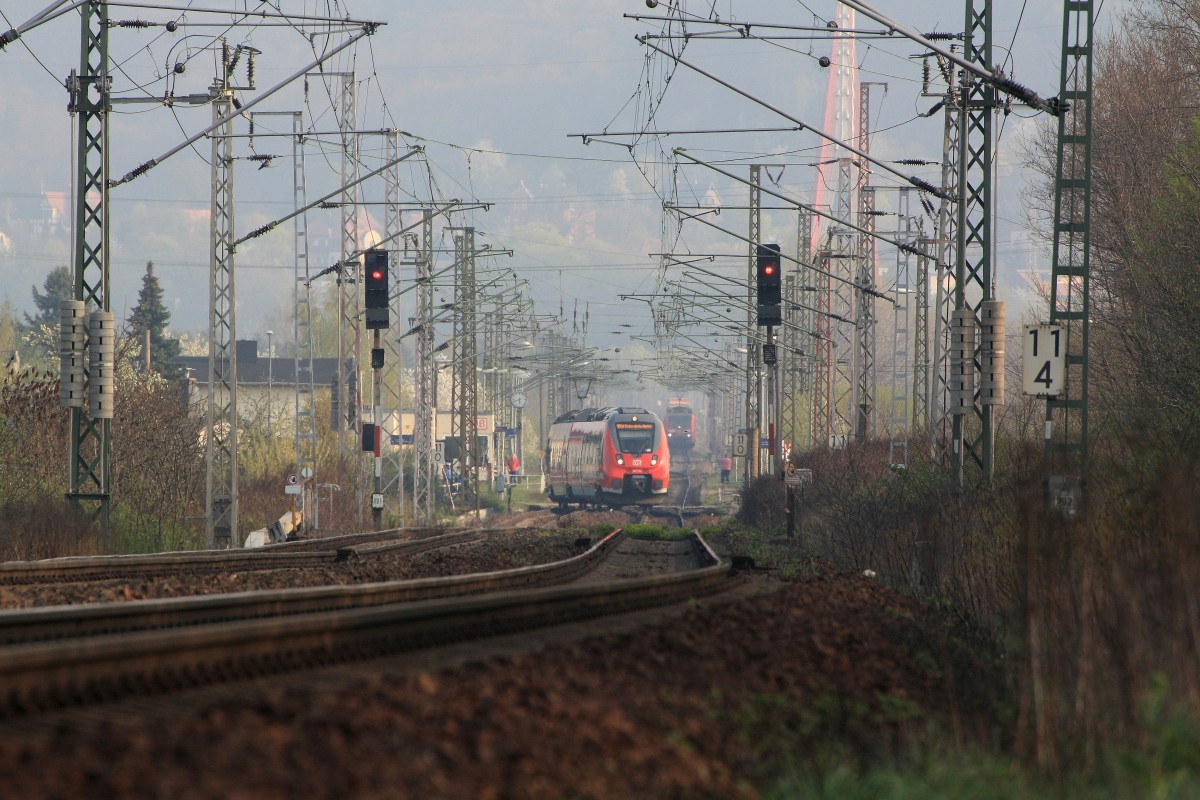 Die RB nach Elsterwerda - Biehla biegt links in die Verbindungskurve nach Coswig  ein, der auf falschem Gleis fahrende Güterzug muss warten.Der rechts stehende Eisenbahnfotograf steht nicht im Gleis. Die Geoposition kennzeichnet den Standort der Fotografin auf der öffentlich zugängigen Baustraße. 06.04.2014 16:51 Uhr 