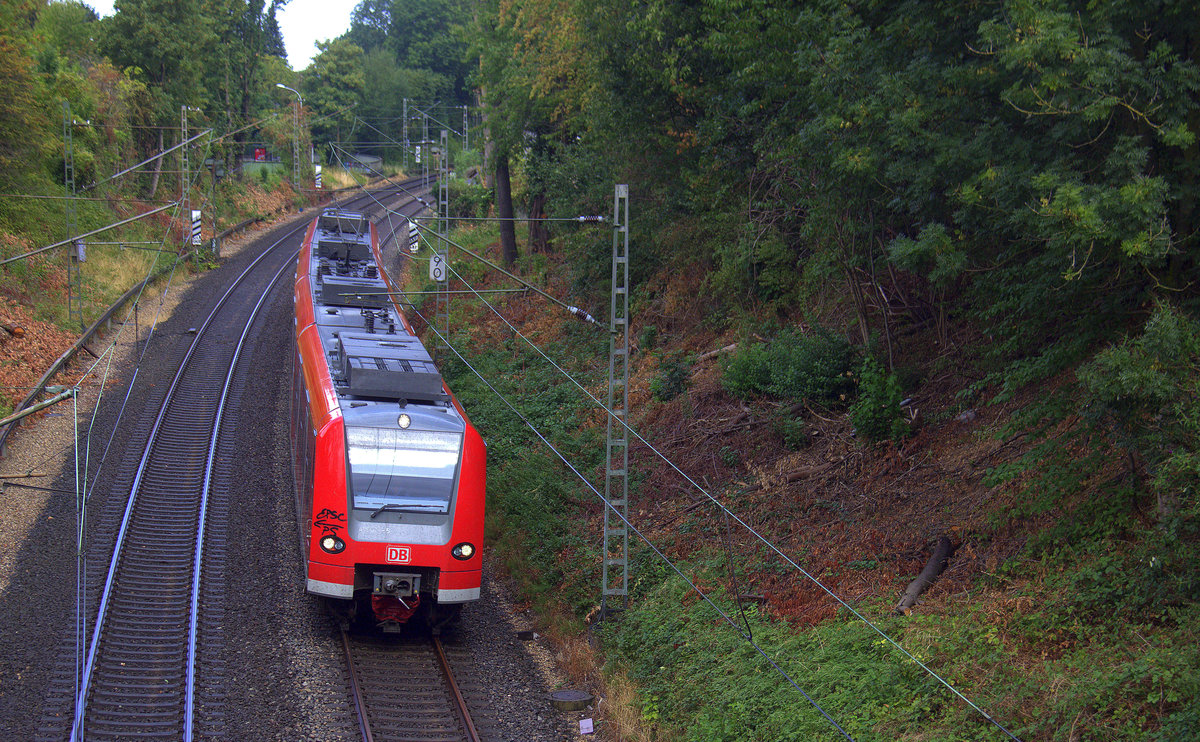 Die RB33 aus Geilenkirchen nach Aachen-Hbf und kommt aus Richtung Herzogenrath,Kohlscheid und fährt durch Richterich  in Richtung Laurensberg,Aachen-West,Aachen-Schanz,Aachen-Hbf. Aufgenommen von einer Brücke Horbacherstraße in Richterich bei Aachen.
Bei Regenwolken und Sonne am Mittag vom 25.8.2018.