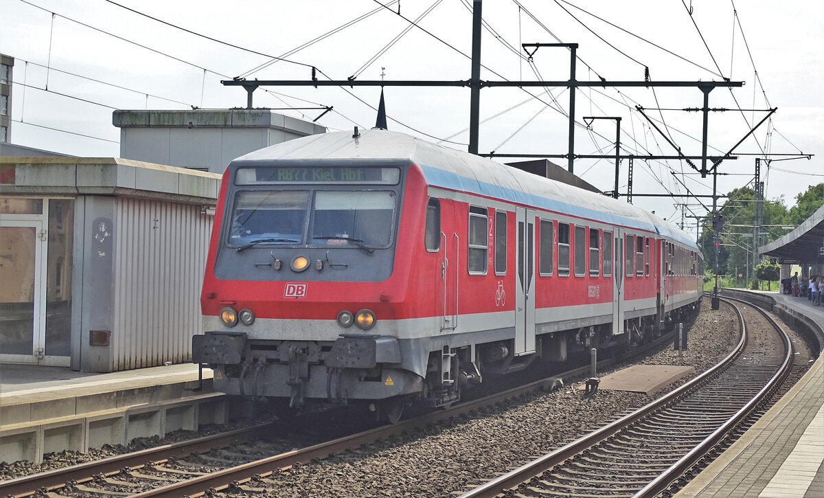 Die RB77 Neumünster - Kiel Hbf im Startbahnhof Neumünster. Zum Einsatz kamen bis 2015 Garnituren bestehend aus n-Wagen, bis 2017 aus im- und y-Wagen und anschließend n-Wagen, y-Wagen, MODUS-Wagen gemischt. Seit 2018 existiert diese Linie nicht mehr und ist Teil des RE7.
Aufgenommen im Juni 2016. Der Steuerwagen der Bauart Bybdzf 482.4 ist einer der vier Exemplare dieses Typs, die 2005 für den SH-Express Hamburg - Flensburg umgebaut wurden und als einzige Halberstädter Mitteleinstiegswagen für 160 km/h zugelassen waren und Schwenkschiebetüren besaßen.