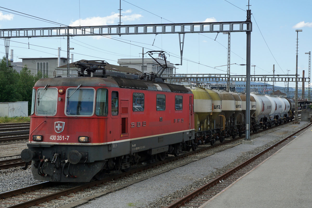 Die Re 430 351-7 mit einem Zementzug in Zofingen am 6. Juli 2020.
Besondere Beachtung gilt den drei nostalgischen Zementwagen, eingereiht hinter der Lok.
Foto: Walter Ruetsch
