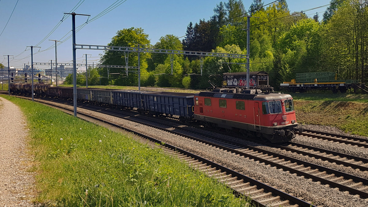 Die Re 4/4  11272 (420 272-7) mit der speziellen Aufschrift  100. Klimaanlage eingebaut im IW Biel Juli 2006  fährt mit einem Güterzug Ausgangs Effretikon richtung Bassersdorf am 23.04.2020.