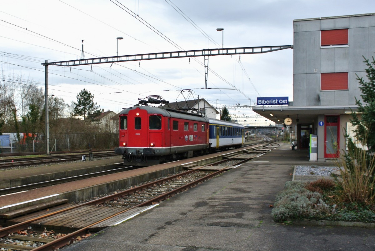 Die Re 4/4 I 10009 berfhrte heute den AB EWI 507 von Oberburg via Burgdorf-Solothurn-Oensingen nach Balsthal. Im Bild durchfhrt der berfuhrzug den BLS Bahnhof Biberist Ost, 12.12.2014.