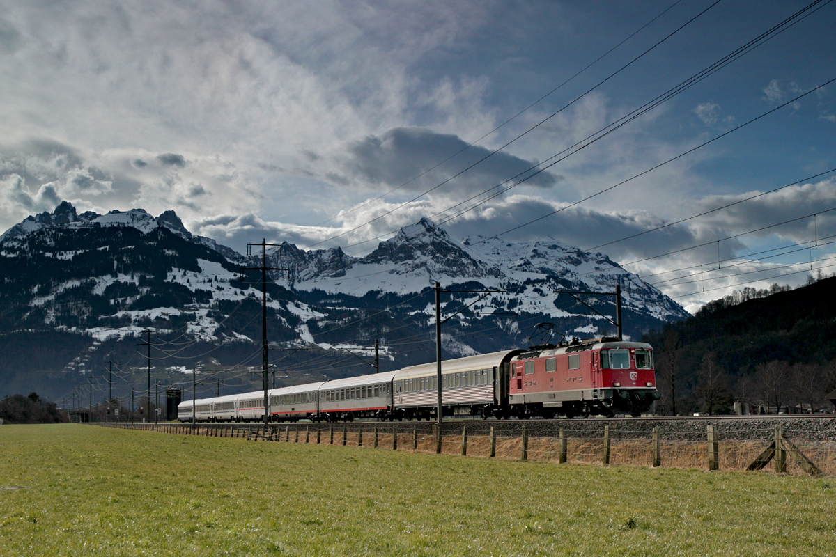 Die Re 4/4 II 11111 fährt mit dem EN aus Beograd nach Zürich HB am Morgen des 17.3.2015 in Bilten vorüber bei einer starken Südföhnlage.
