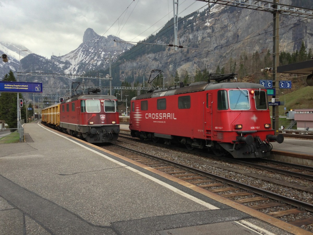 Die Re 4/4 II 11190 berholt mit Ihrem Postzug die Crosssrail Re 436 112-7 am Abend des 12.04.2014 in Kandersteg.
