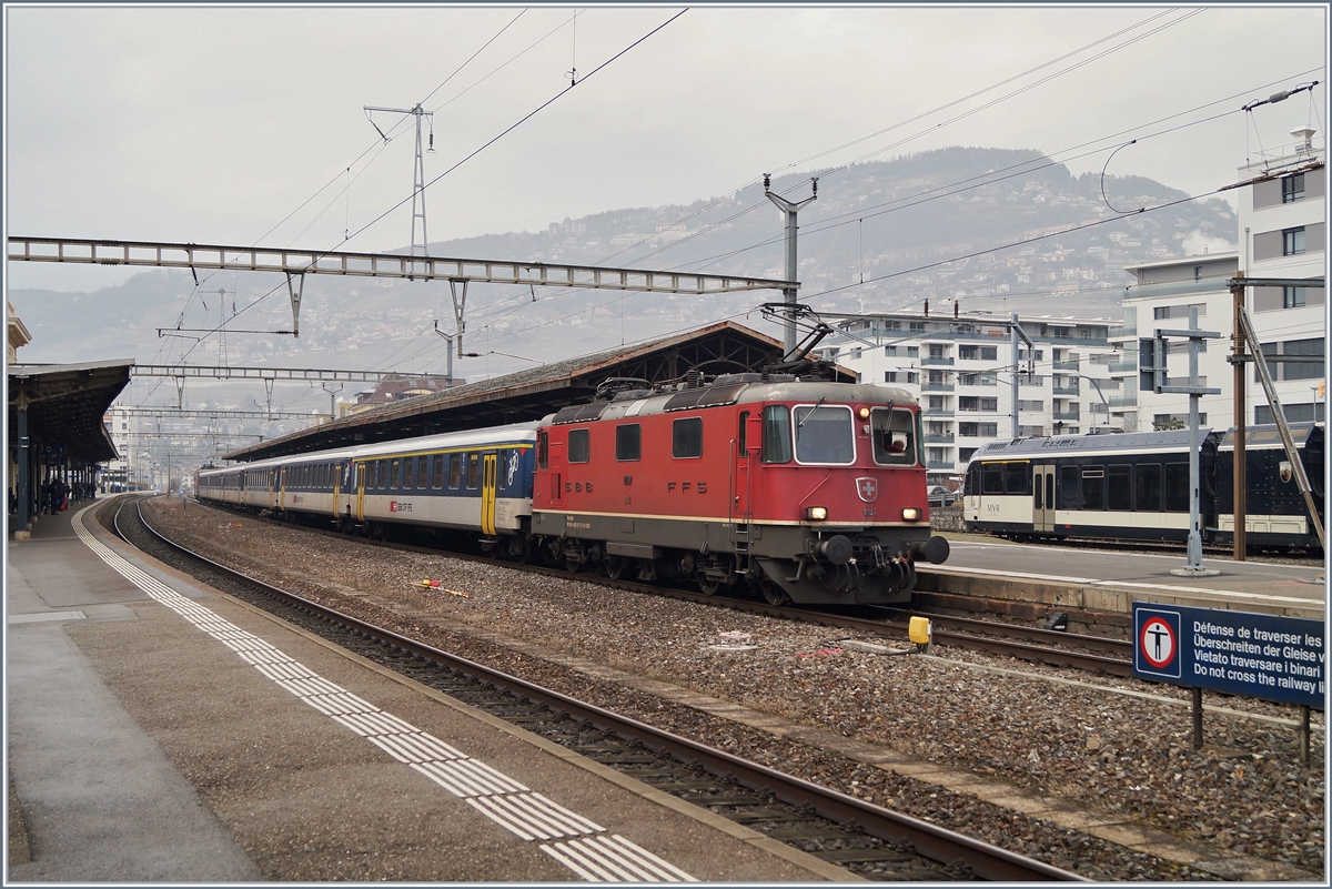 Die Re 4/4 II 11197 wartet in Vevey mit ihrem Dispozug  (und der Re 4/4 II 11194 am Zugschluss) als IR90 1725 auf die Ausfahrt. 

30. Januar 2020