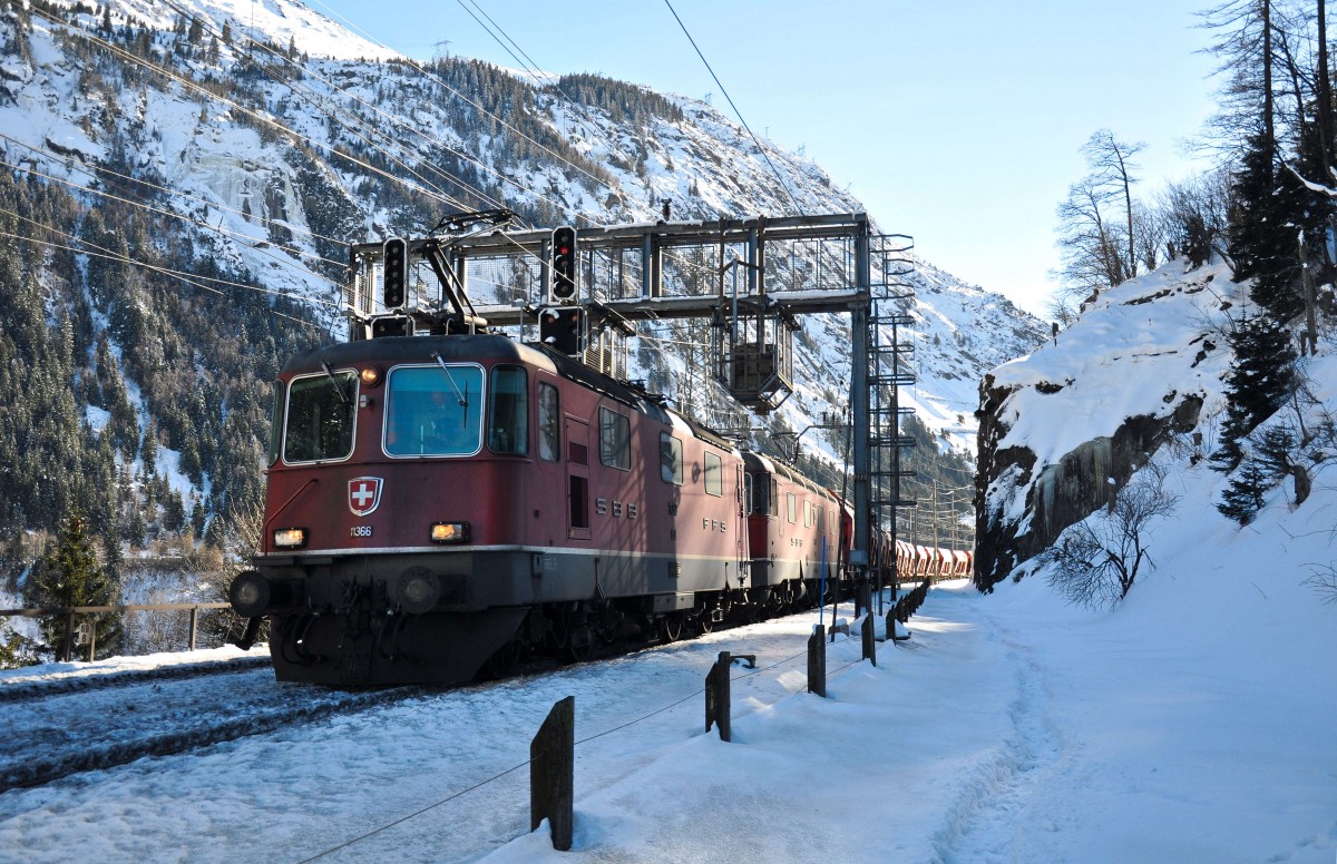 Die Re 4/4 III 11366 führt zusammen mit einer Re 6/6 einen Kieszug den Gotthard hinunter, aufgenommen bei Göschenen am 10.02.2015.