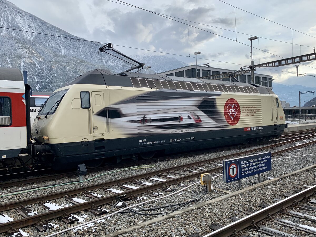 Die Re 460 019 mit der Werbung 175 Jahre Schweizer Bahnen am 2.4.22 im Bahnhof Brig.