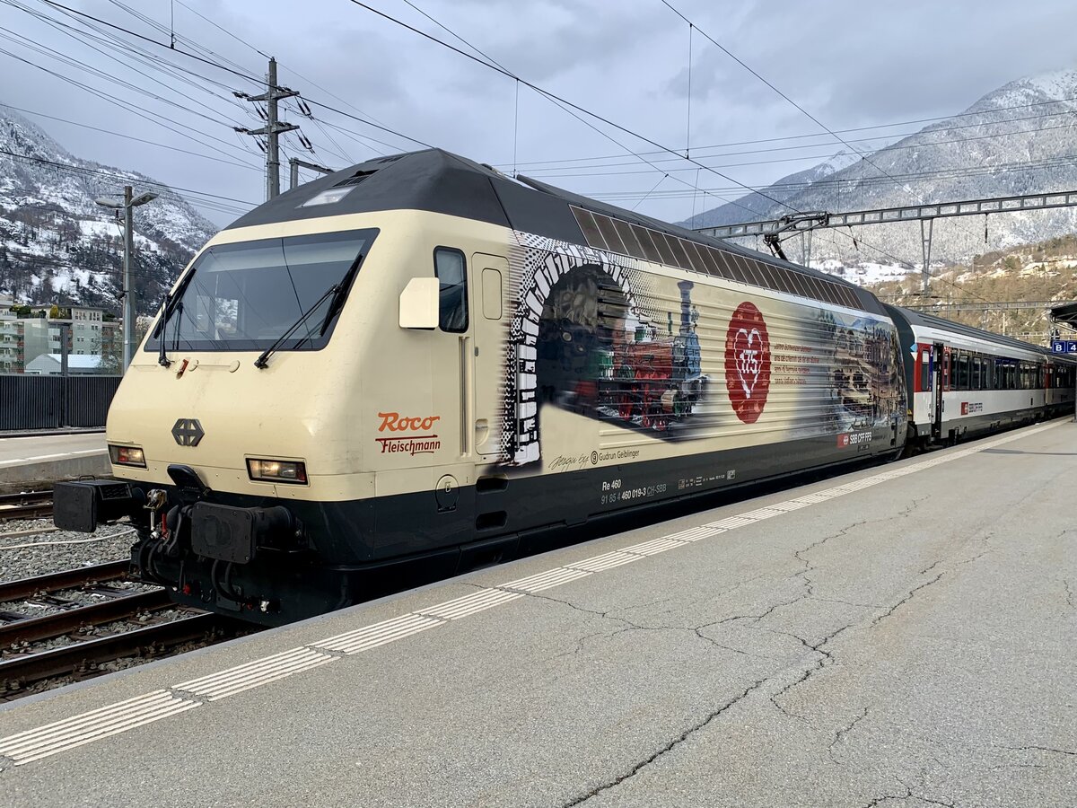 Die Re 460 019 mit der Werbung 175 Jahre Schweizer Bahnen am 2.4.22 im Bahnhof Brig.