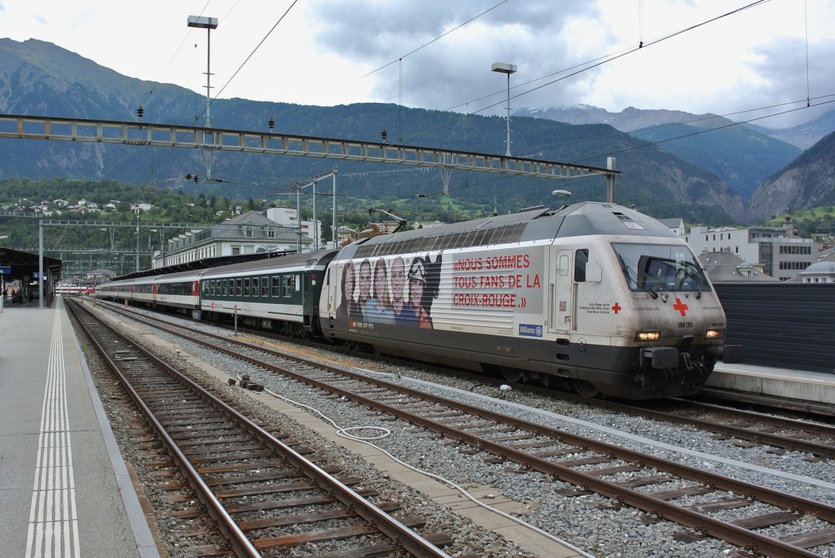 Die Re 460 041-7  SRK  steht mit ihrem IR 1720 abfahrbereit nach Genève-Aéroport in Brig. Bei diesem Zug sind alle 5 2. Kl. Wagen (normalerweise EWIV) durch ehem. Bpm51 ersetzt, wobei der vorderste (50 85 21-73 399-0) sogar noch im alten Anstrich verkehrt. Im Rhonetal werden diese B in der Regel nur noch als Zusatzwagen eingesetzt, und normalerweise auch nur die umlackierten, 15.09.2015.