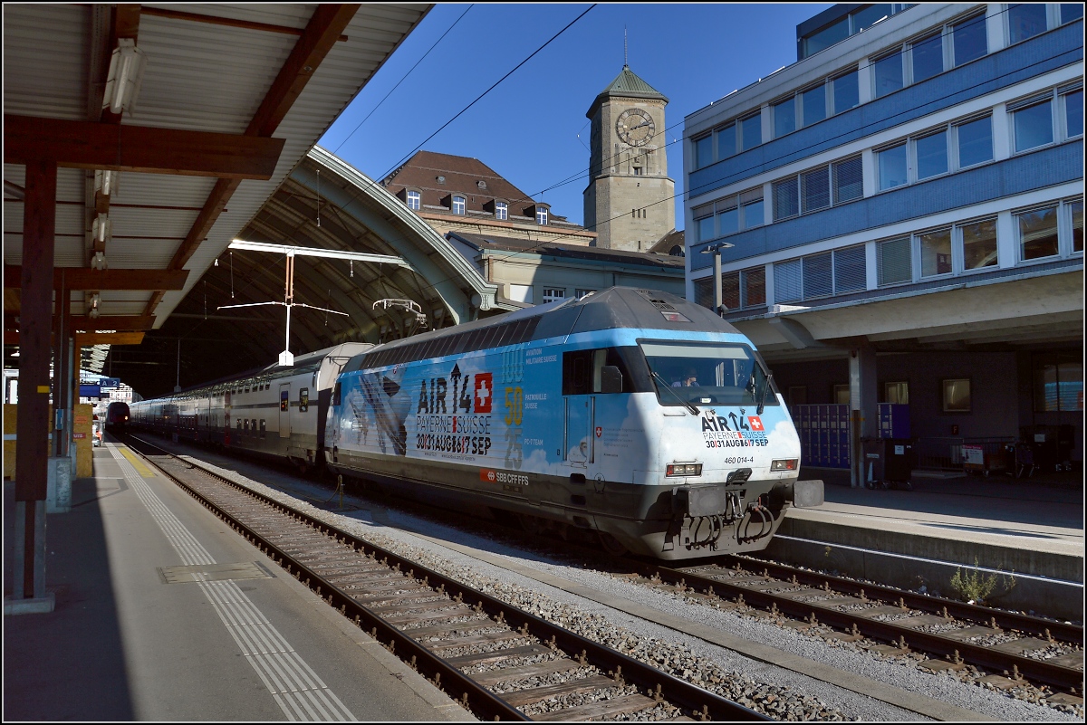Die Re 460 104-4 mit Werbung für die Air 14. Im Hintergrund der monunmentale Turm des finsteren Postkolosses von St.Gallen. November 2014.