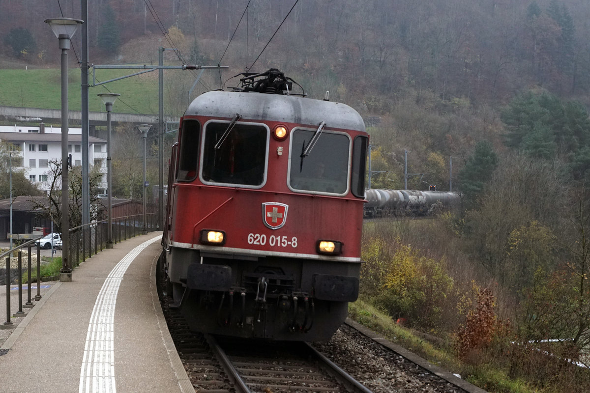 Die Re 620 015-8  KLOTEN  mit dem Güterzug RBL - Reuchenette-Péry bei der Haltestelle Frinvillier-Taubenloch am sehr trüben 26. November 2019.
Foto: Walter Ruetsch